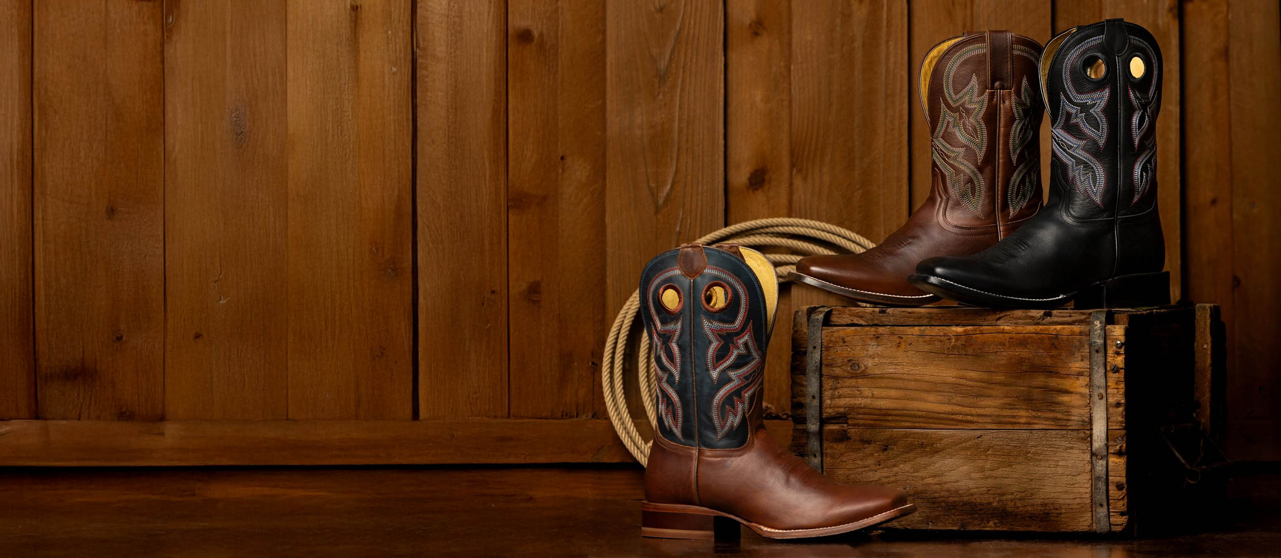 A lineup of the Men’s Ranchero collection in front of a wood wall.
